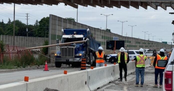 Part of QEW closed after dump truck with raised bin crashes into bridge overpass
